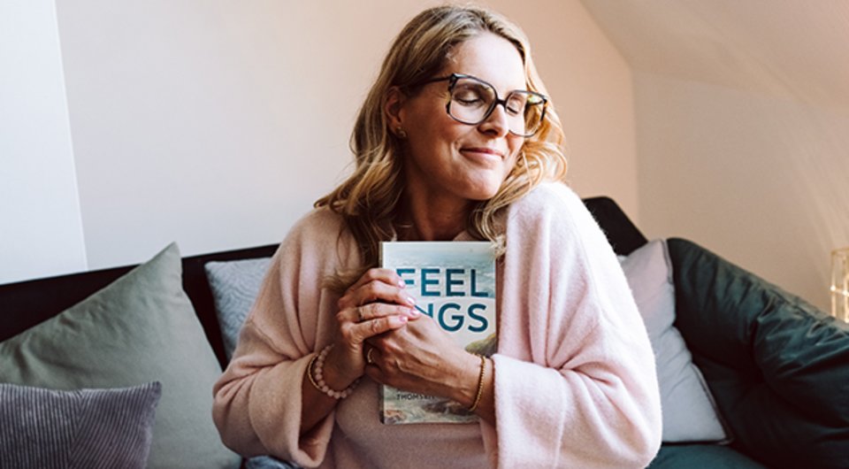 Eine glückliche Autorin, die ihr erstes eigenes Buch in den Händen hält